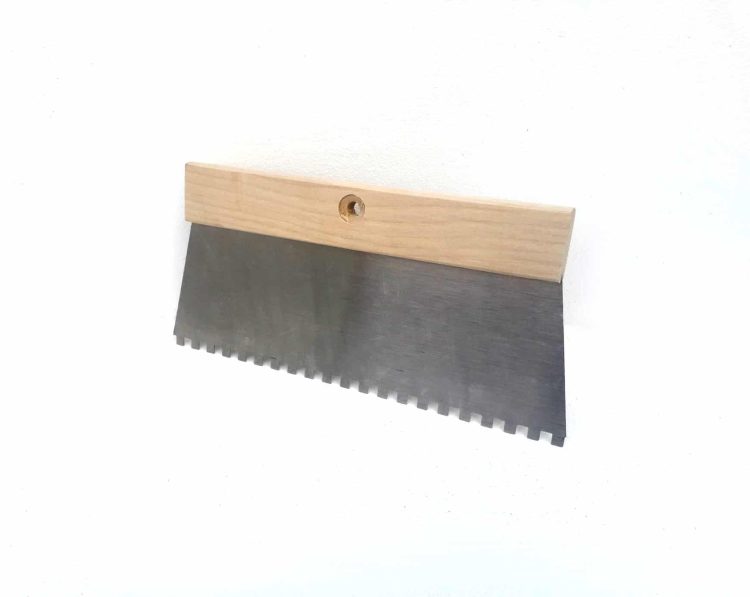 Wall tile adhesive comb for spreading adhesive