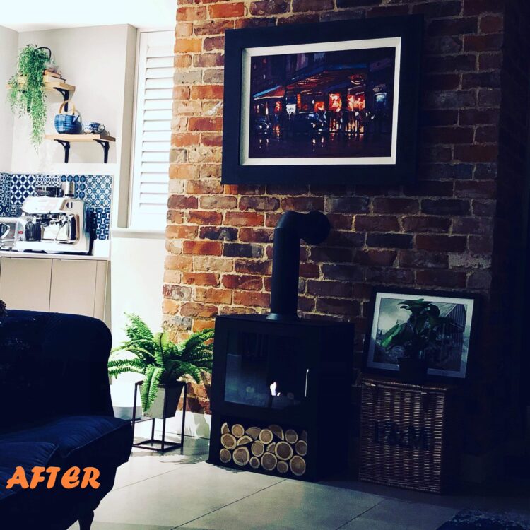 A chimney breast cladd in reclaimed bricks. The bricks are varying shades of red, brown, black, white and have old mortar stuck to the faces.