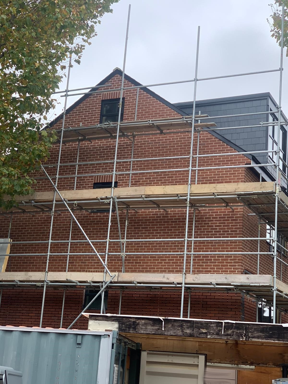 A house under construction with scaffold boards around the front elevation. It is built using brick slips as the brick veneer.